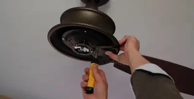 Electrician installing ceiling fan mounting bracket and fixture in Louisville, KY