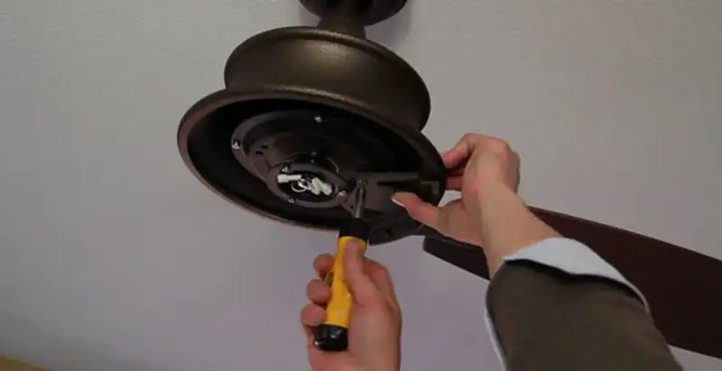 Electrician installing ceiling fan mounting bracket and fixture in Louisville, KY