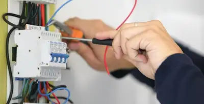Electrician installing and adjusting circuit breakers in an electrical panel in Louisville, KY