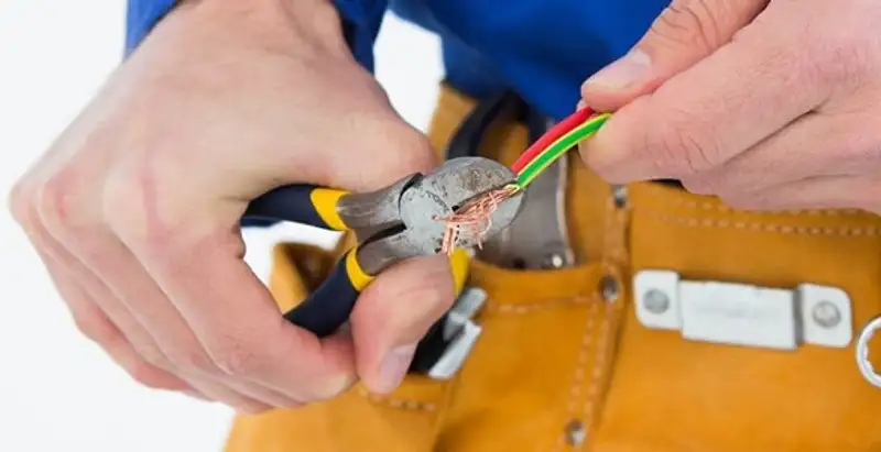 licensed electrician securing electrical wiring with professional tools during service work in Louisville, KY