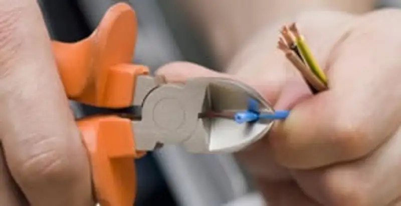 licensed electrician performing precise wire cutting and preparation during electrical service in Louisville, KY