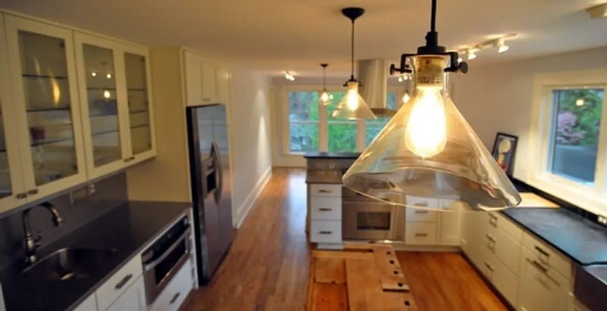 Residential electrician installing modern indoor light fixture in a home in Louisville, KY
