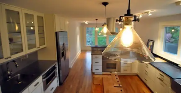 Residential electrician installing modern indoor light fixture in a home in Louisville, KY